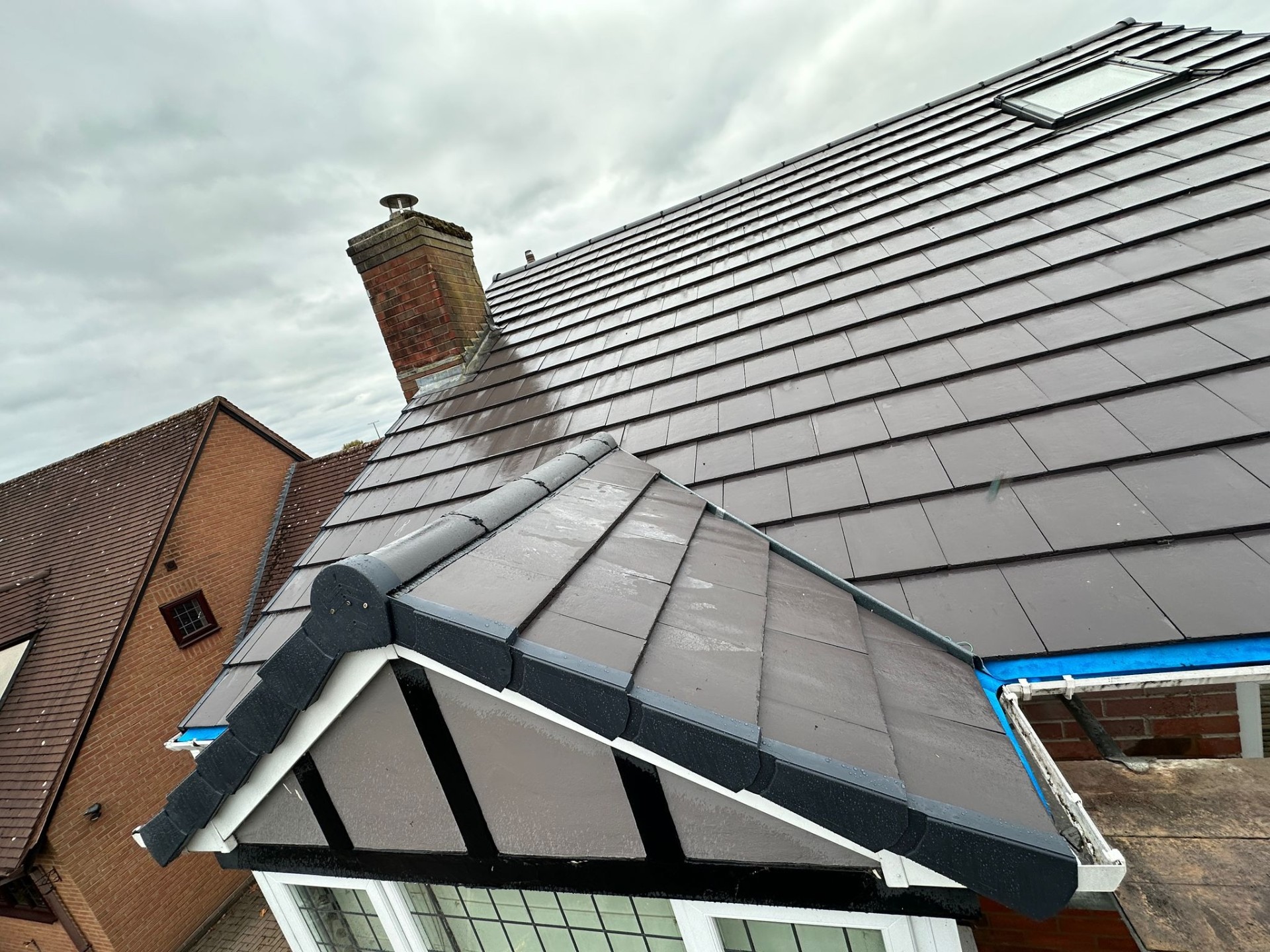 Completed new roof installation with dark slate tiles and dry ridge system on a residential property in Stoke-on-Trent