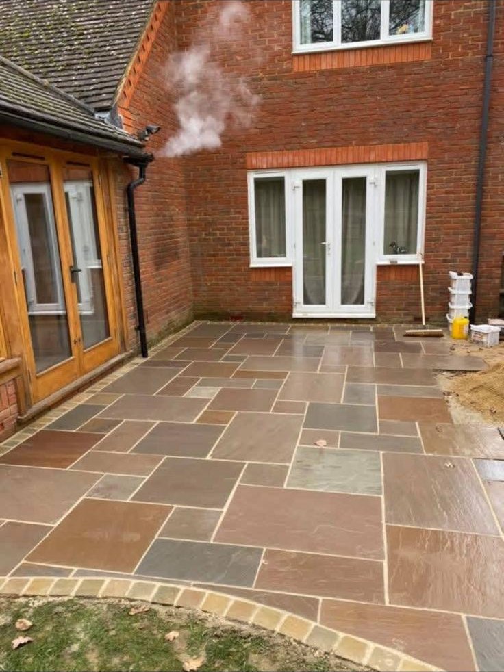 Riven Indian sandstone patio with random pattern at the rear of a brick period home in Malvern